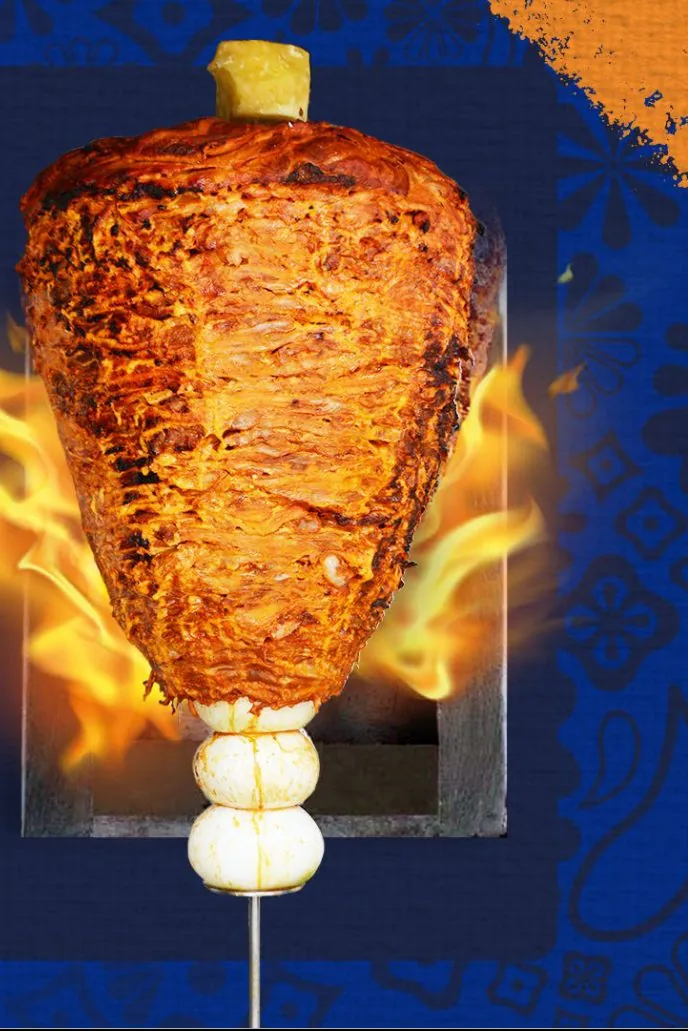 Trompo de carne al pastor con piña sobre el fuego